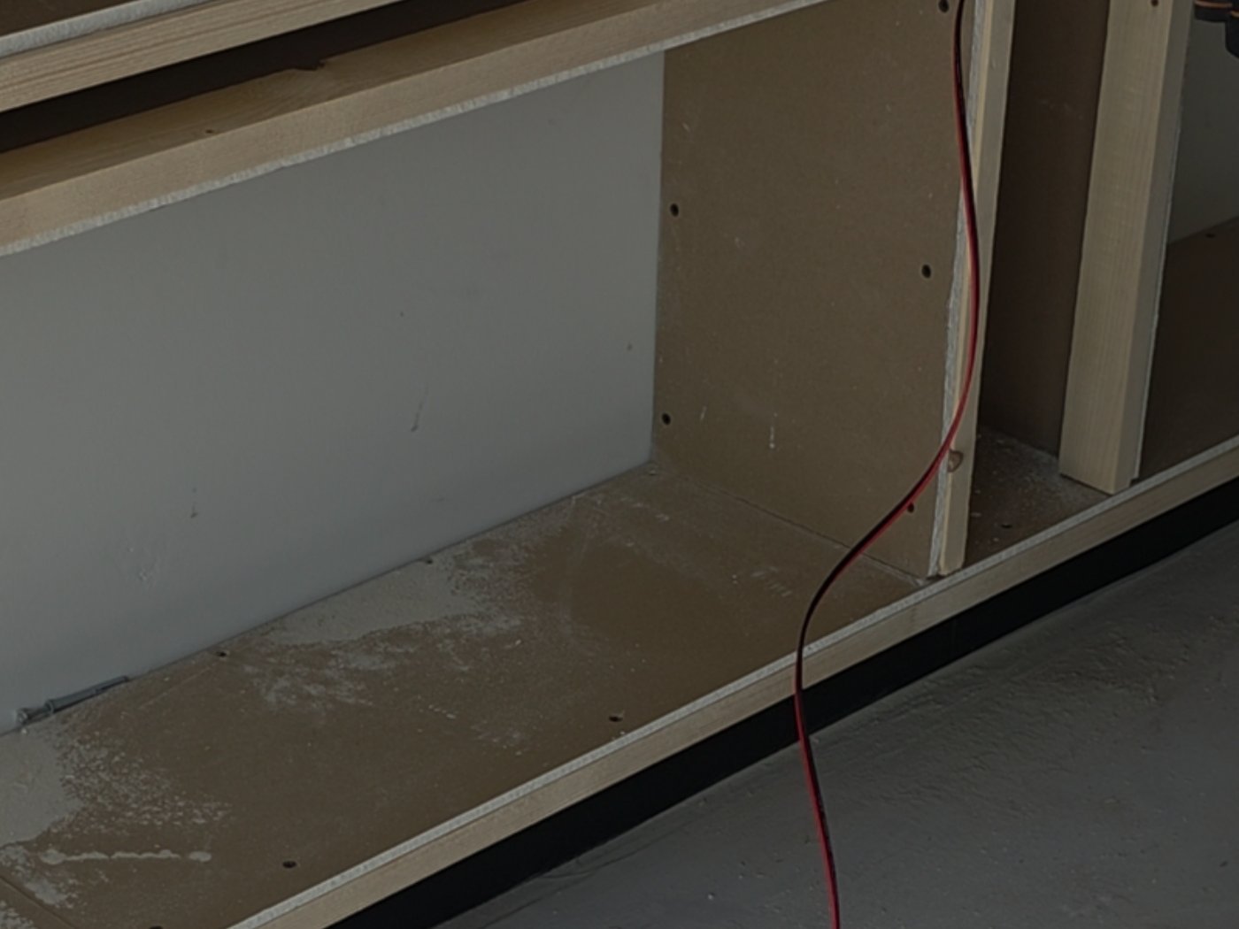 Kabelmanagement in een cinewall: de elektrakabel wordt door het houten frame naar beneden geleid voordat de wand wordt dichtgezet