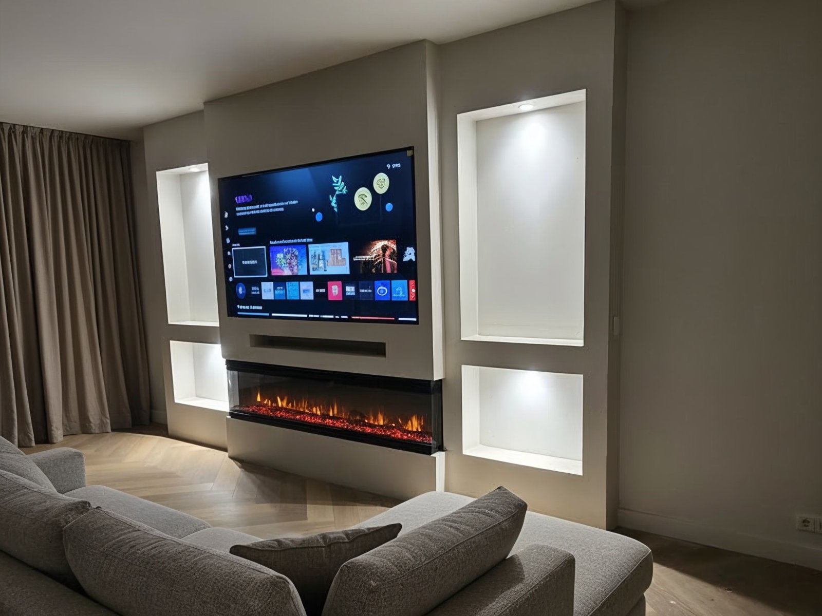 Cinewall met elektrische haard: warm oranje vlambeeld onder de tv met verlichte nissen ernaast in een avondlijke woonkamer