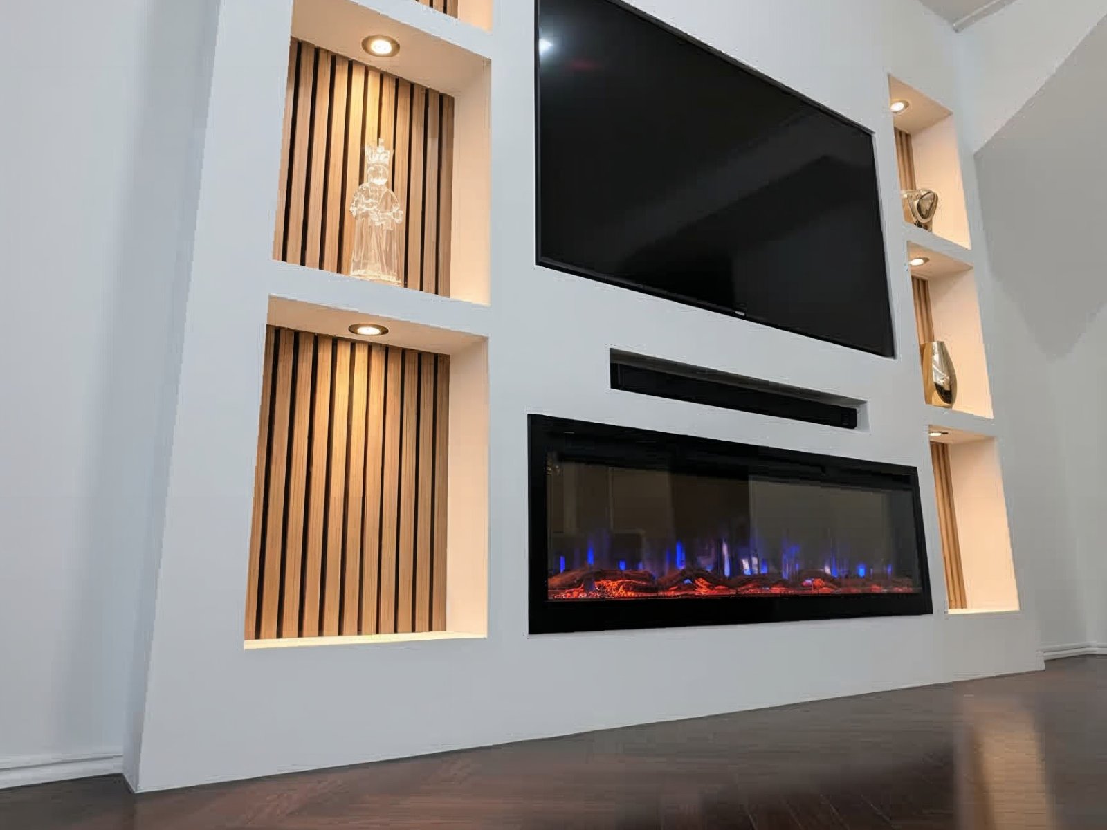 Cinewall met haard en opbergruimte: verlichte nissen met houten panelen naast de tv, met de elektrische haard eronder