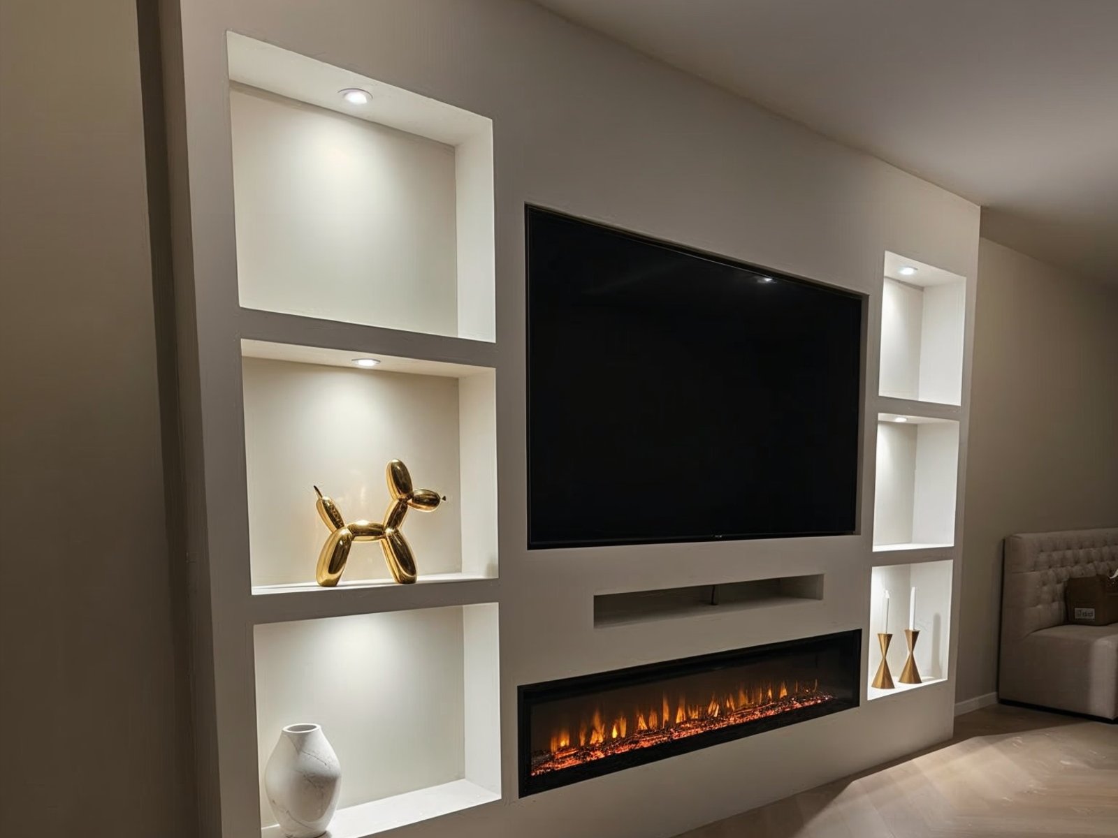 Cinewall met haard en soundbar: de soundbar strak weggewerkt in een nis onder de televisie, boven de elektrische haard