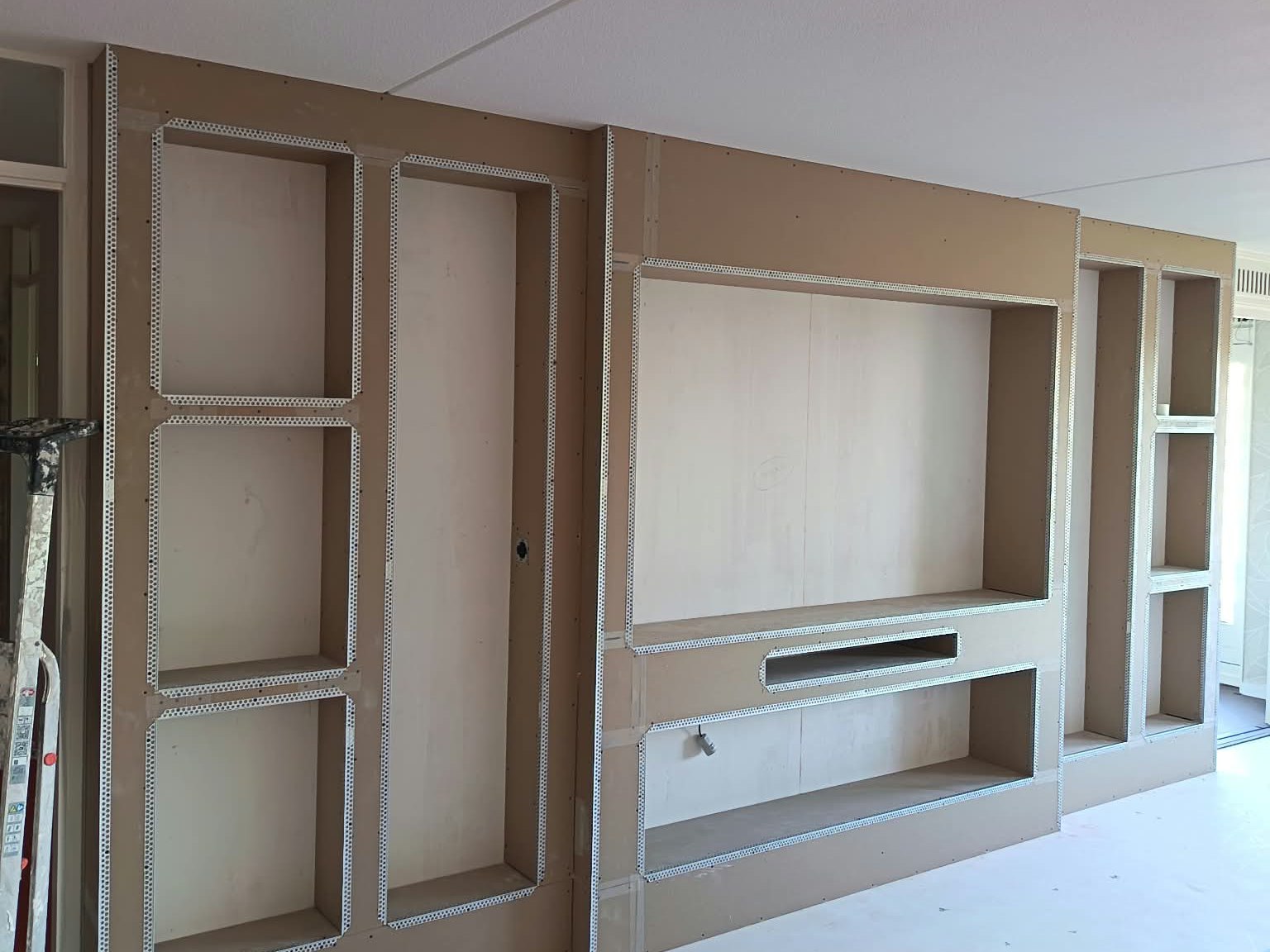 Cinewall in aanbouw: gipsplaten frame met nissen en hoekprofielen, klaar om te stucen