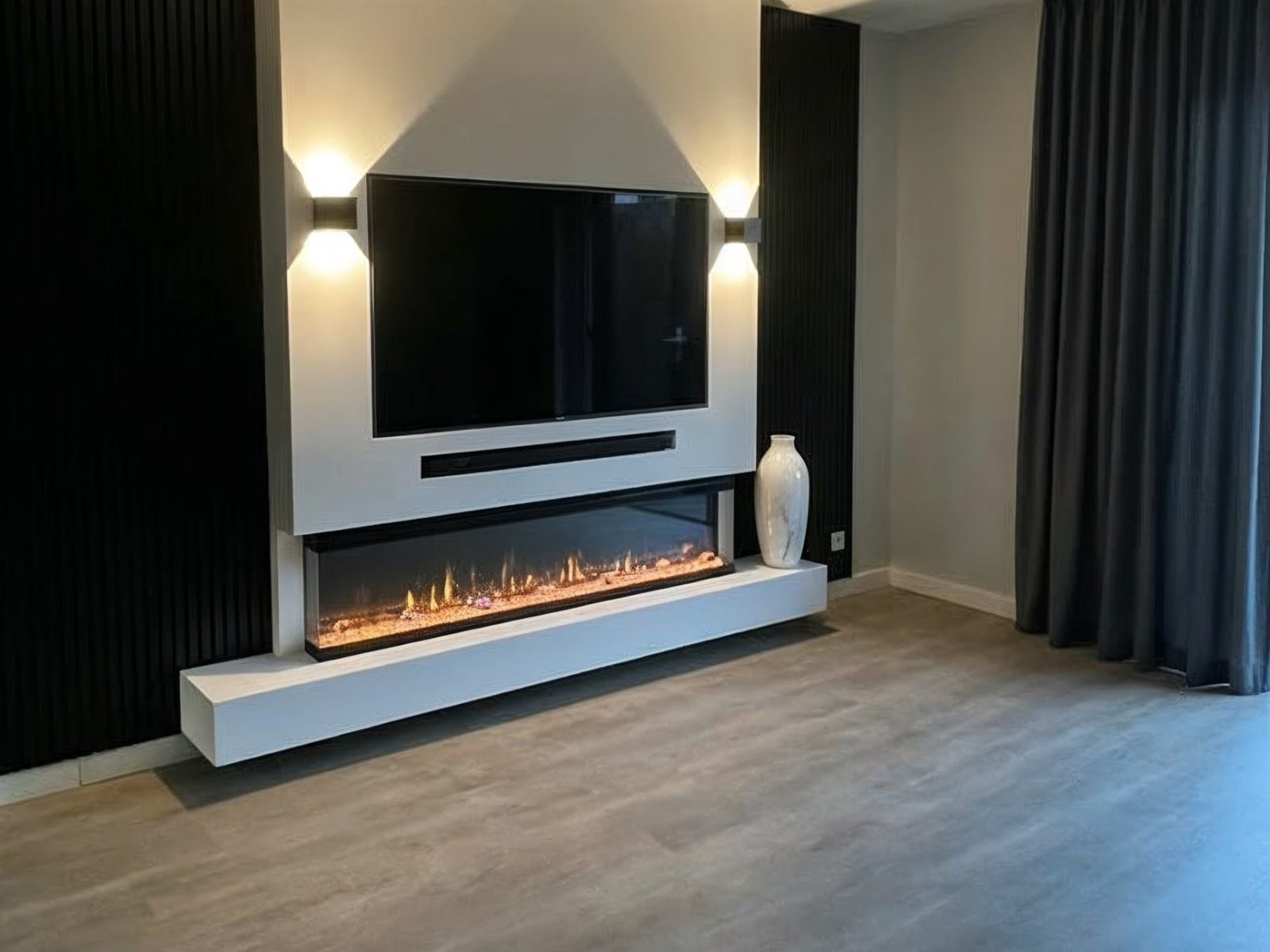 Zwevende cinewall met ingebouwde haard: witte wand met een zwevende bank die los van de vloer hangt, wandlampen en zwarte panelen ernaast