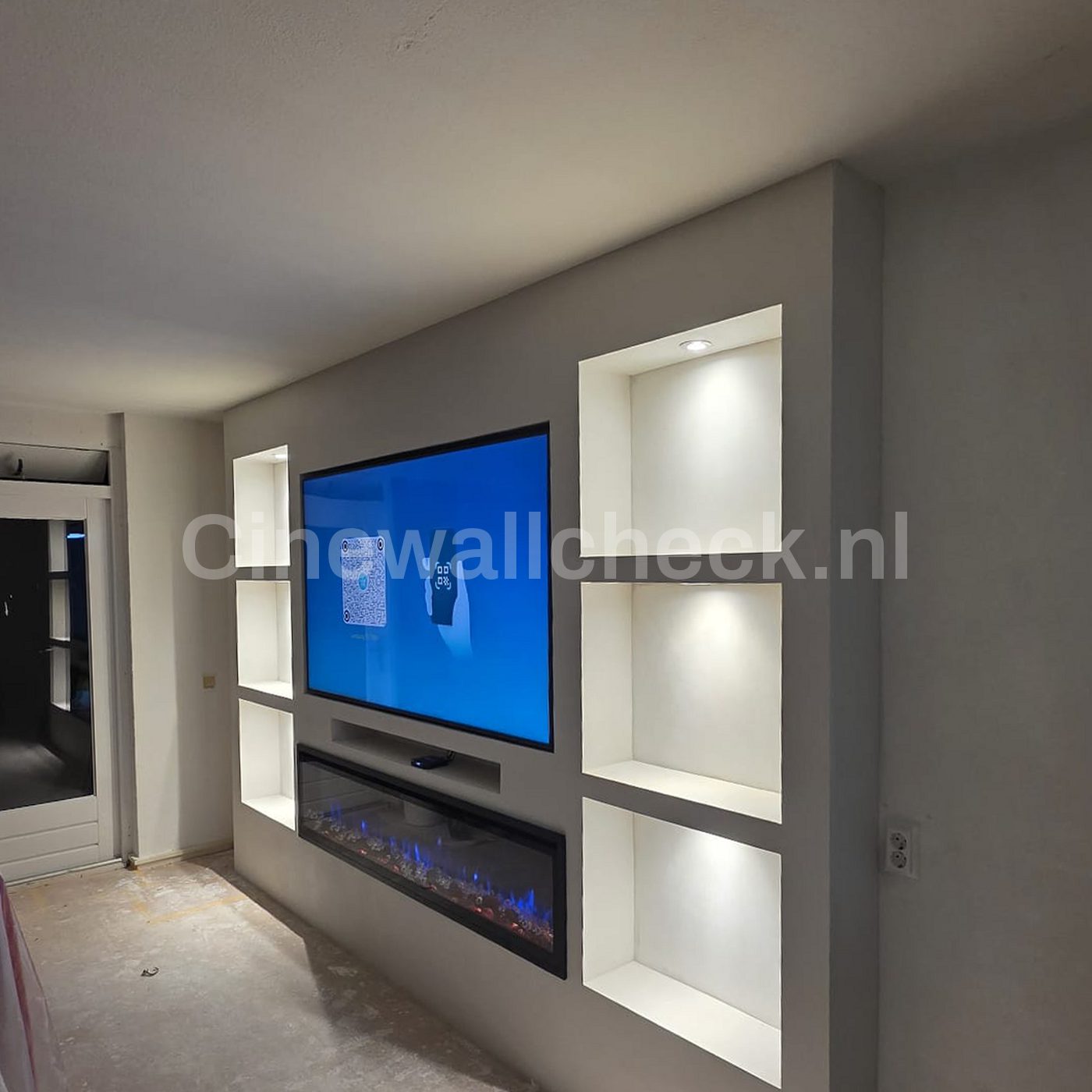 Strakke cinewall met verlichte nissen en een soundbar onder de tv