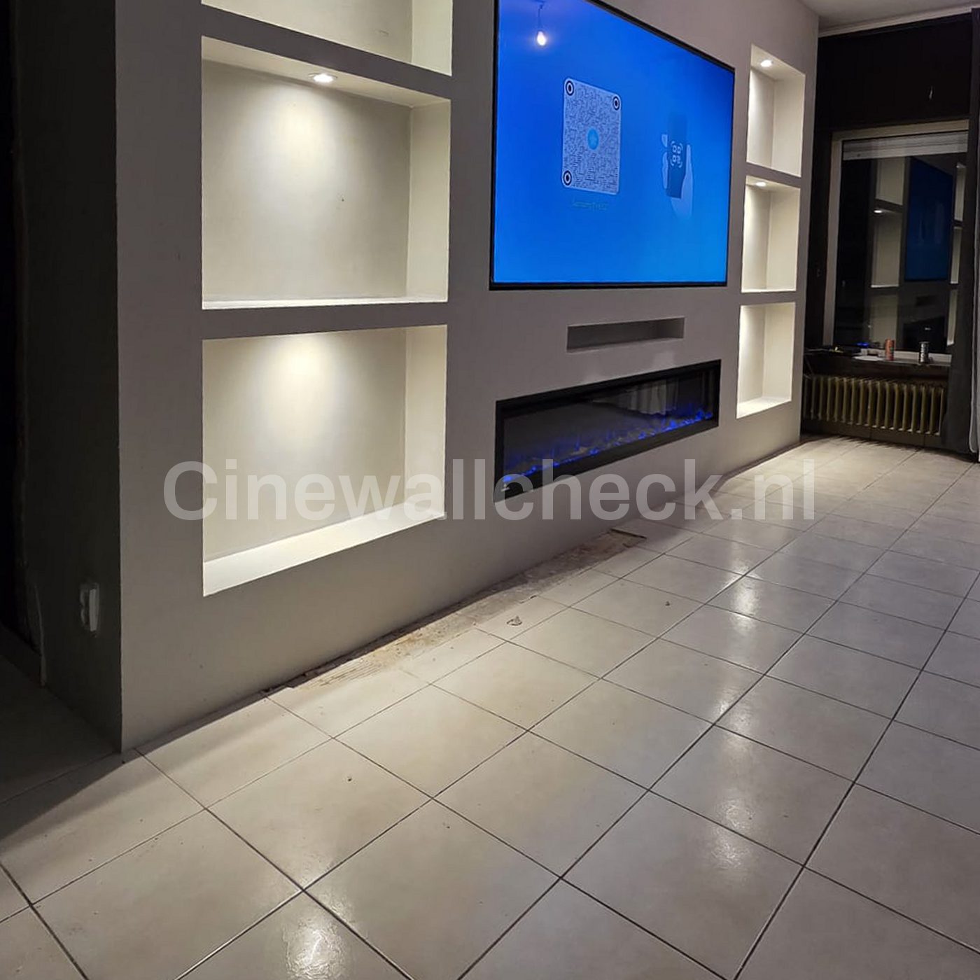 Cinewall met verlichte nissen boven een lichte tegelvloer