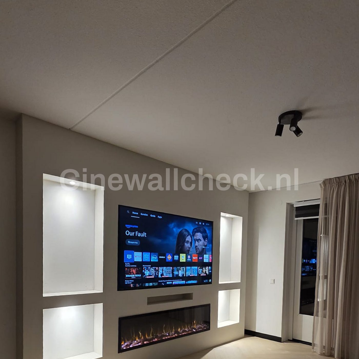 Cinewall met verlichte nissen naast een raam met gordijn