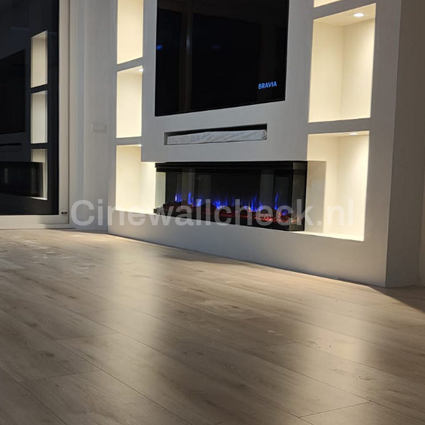 Tv wand met sfeerhaard boven een lichte houten vloer
