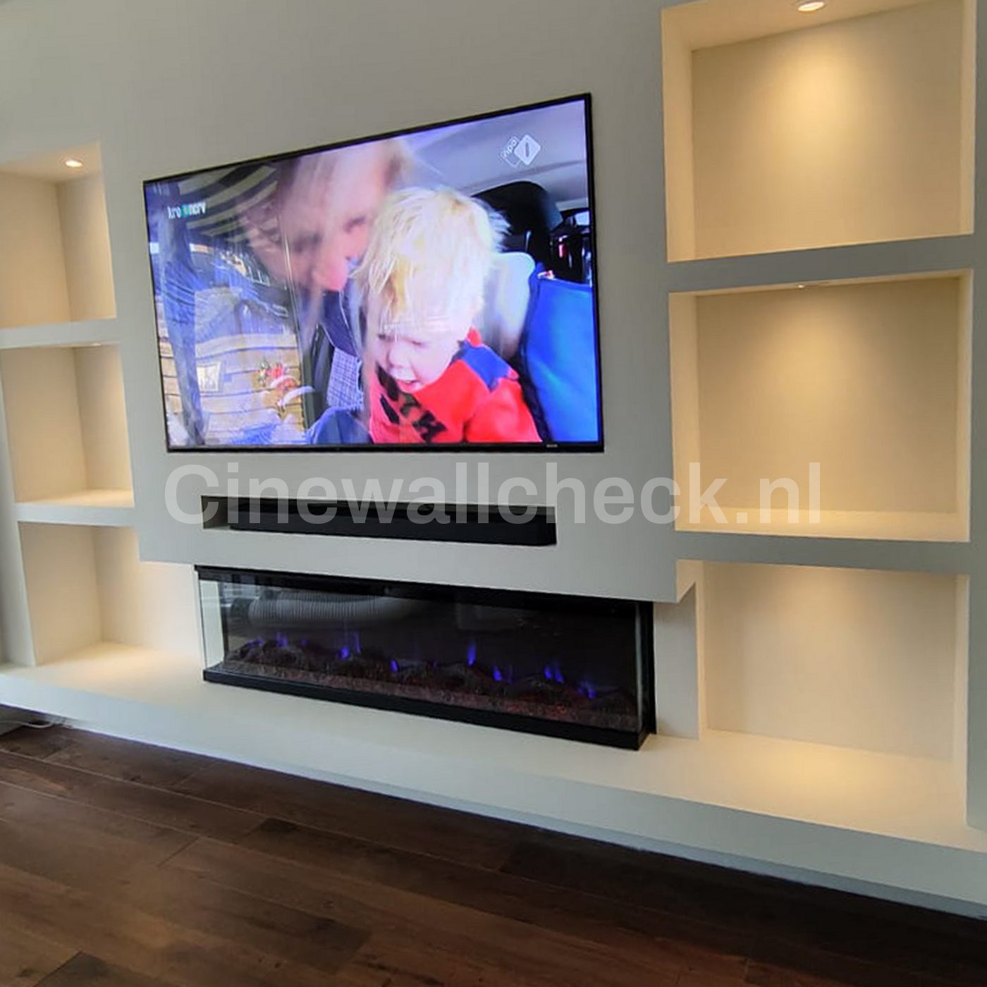 Cinewall met tv, soundbar en een brede elektrische haard