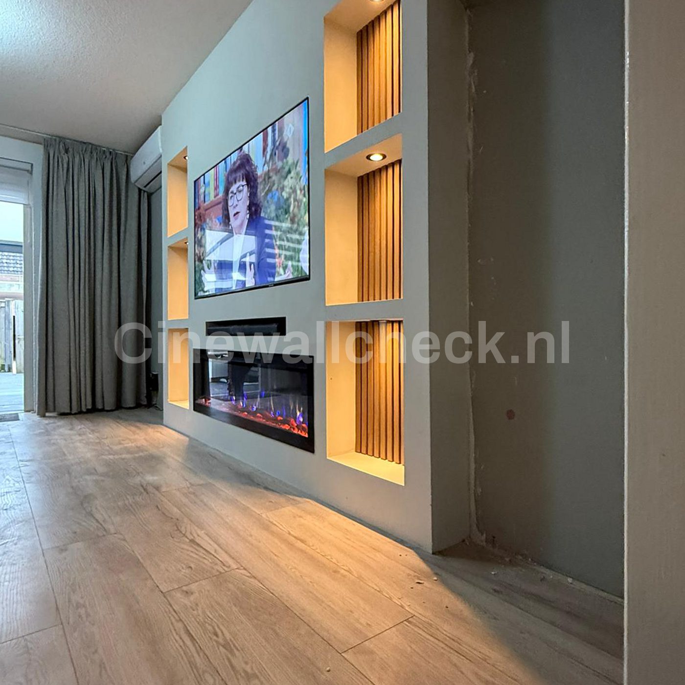 Cinewall met houten panelen en verlichte nissen naast de gordijnen