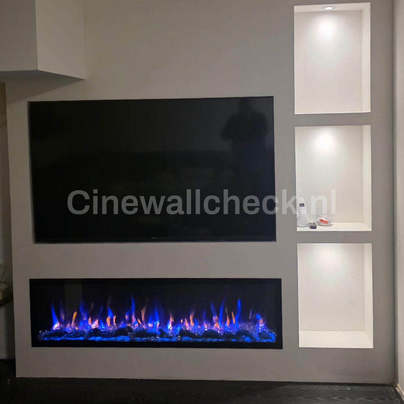 Cinewall met grote tv, blauw vlambeeld en diepe verlichte nissen