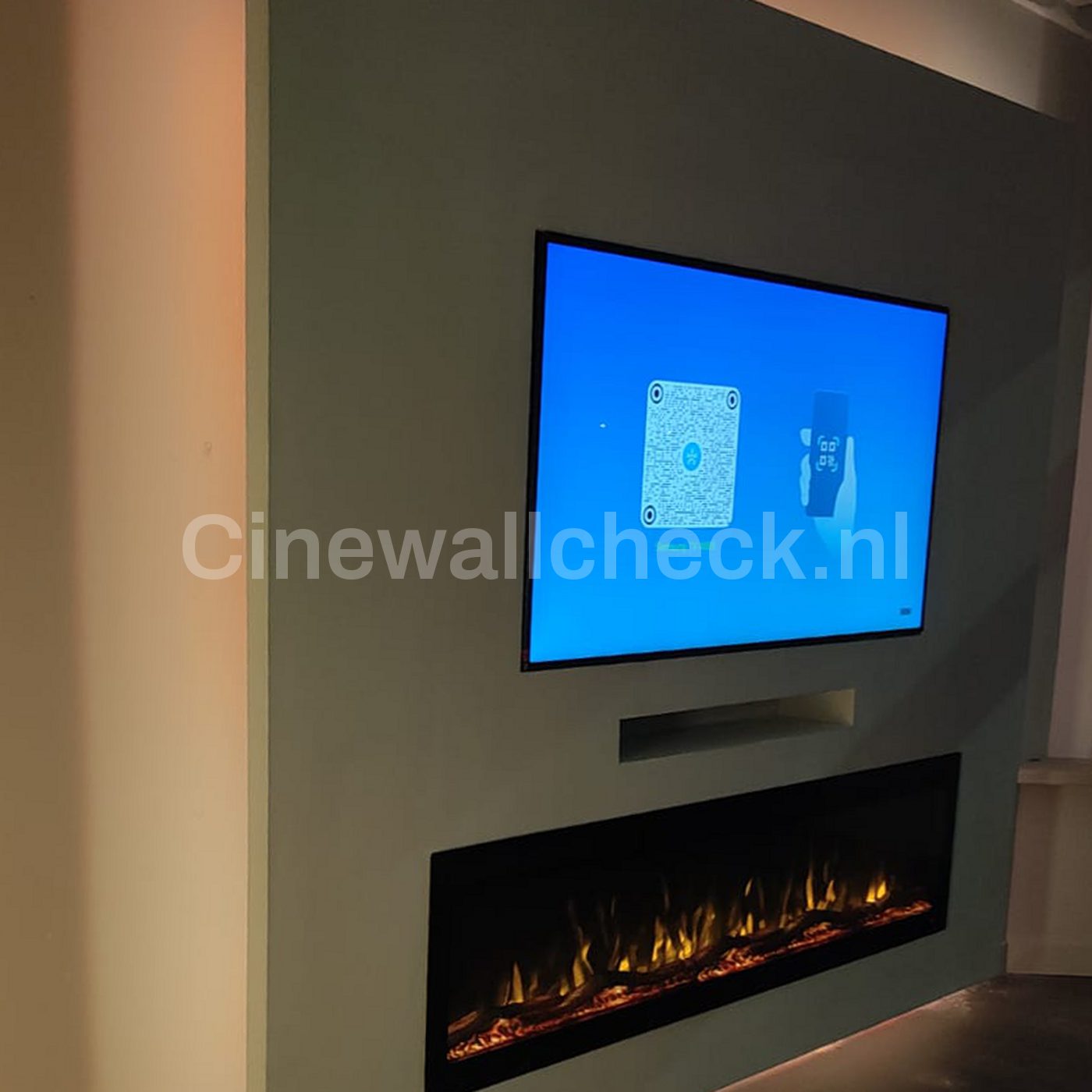 Cinewall met tv en brede haard tegen een donkere wand