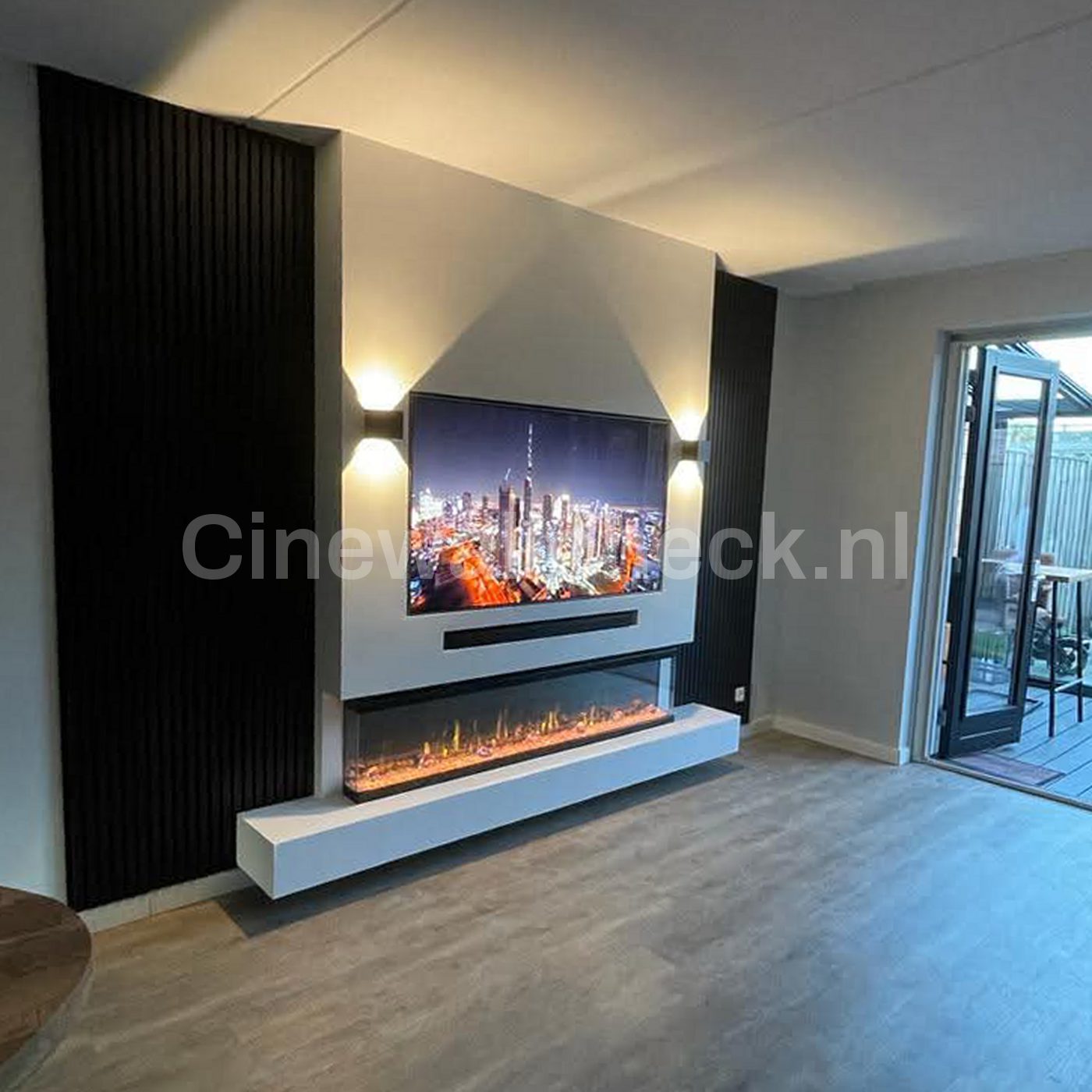Cinewall met zwarte paneelwand en een zwevende haardbank