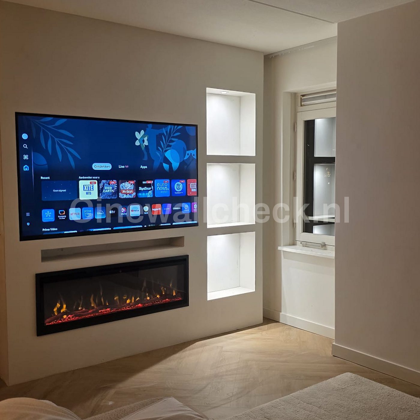 Cinewall met tv, haard en verlichte nissen naast een raam