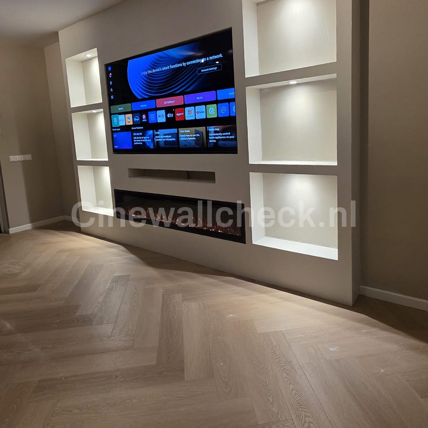 Cinewall met verlichte nissen boven visgraatparket