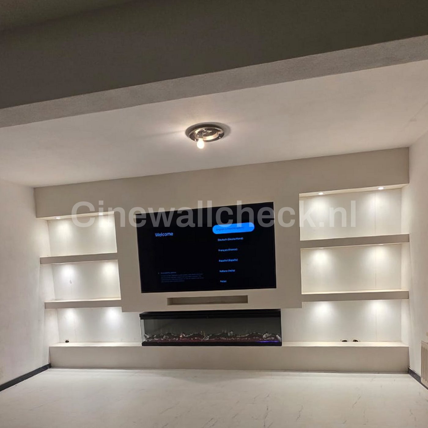 Cinewall met verlichte nissen en een brede haard onder de tv