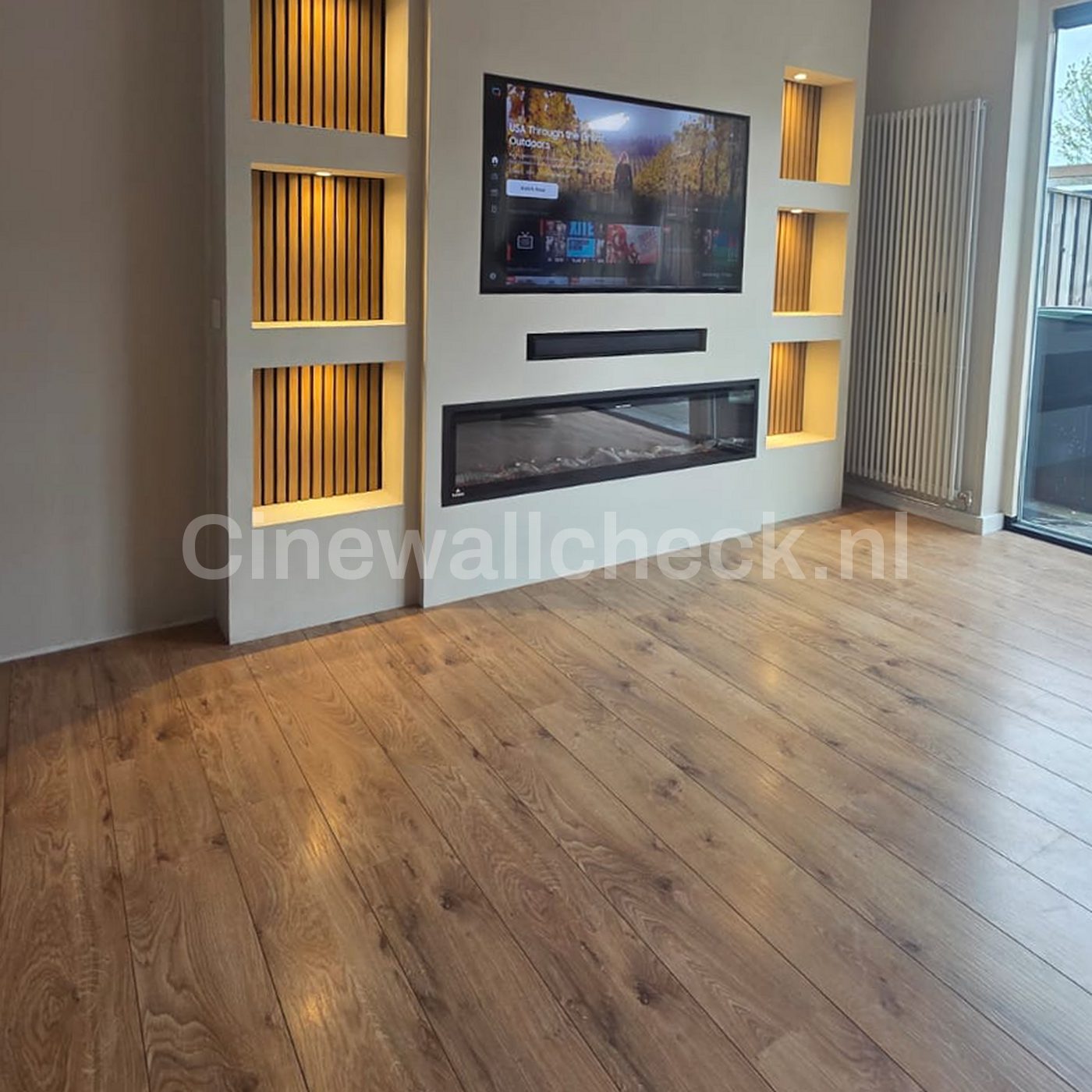 Cinewall met panelen, verlichte nissen en een houten vloer