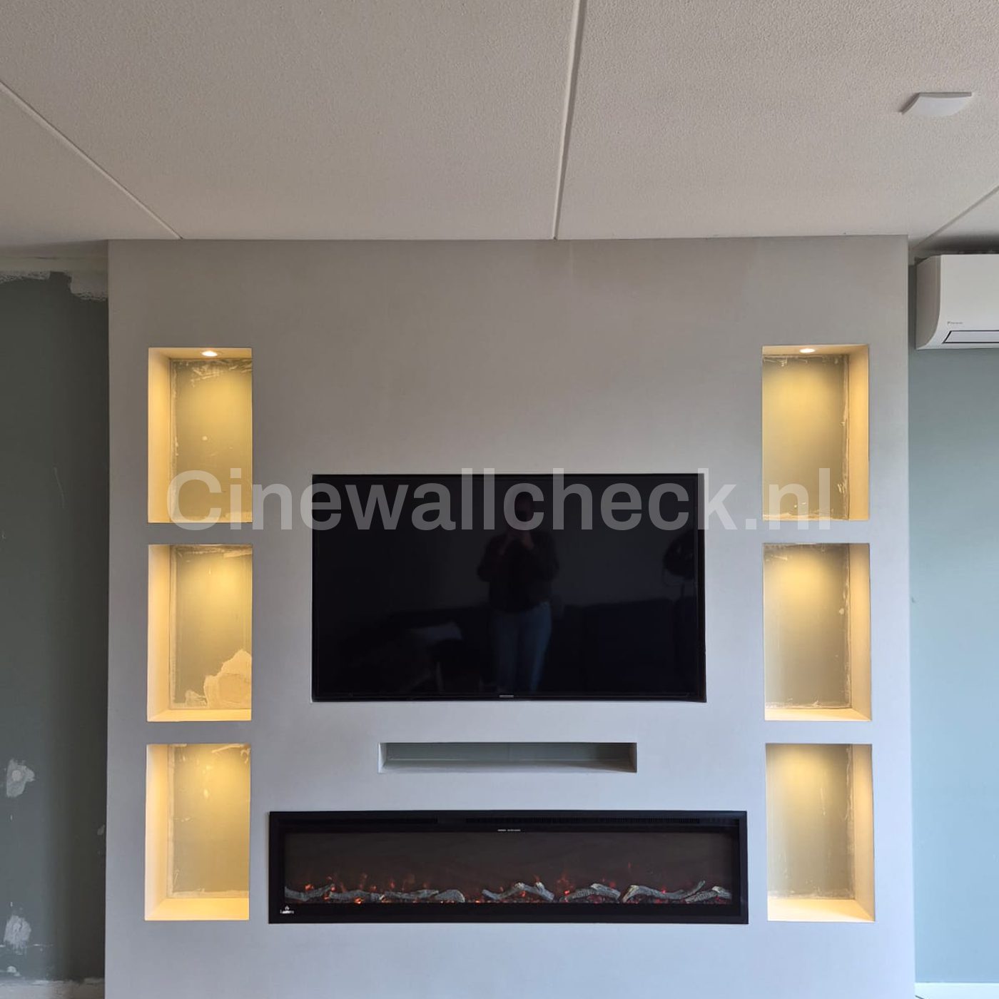 Cinewall met verlichte nissen en haard in een lichte kamer