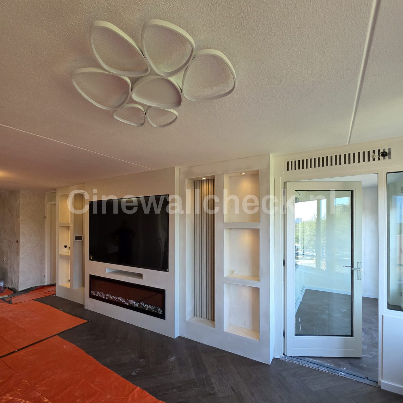 Cinewall met tv en haard in een ruime woonkamer
