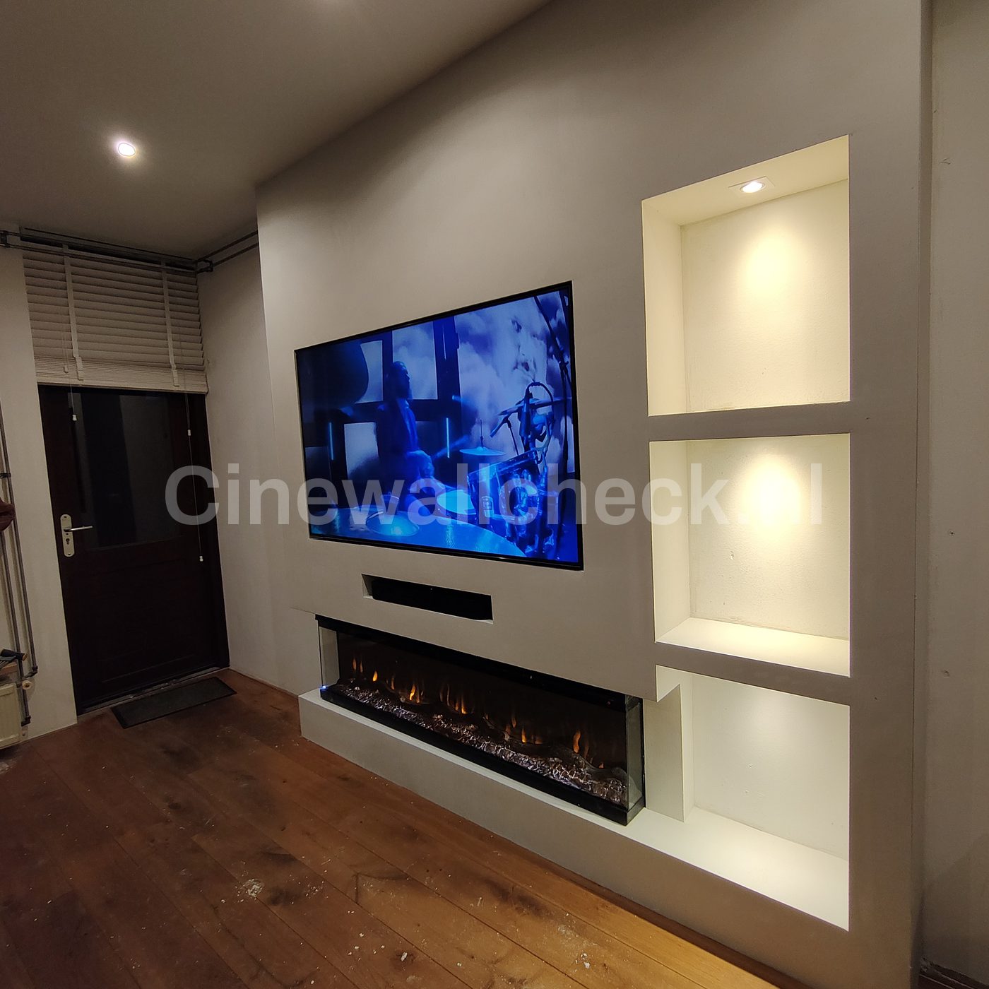 Cinewall met verlichte nissen en tv naast een deur