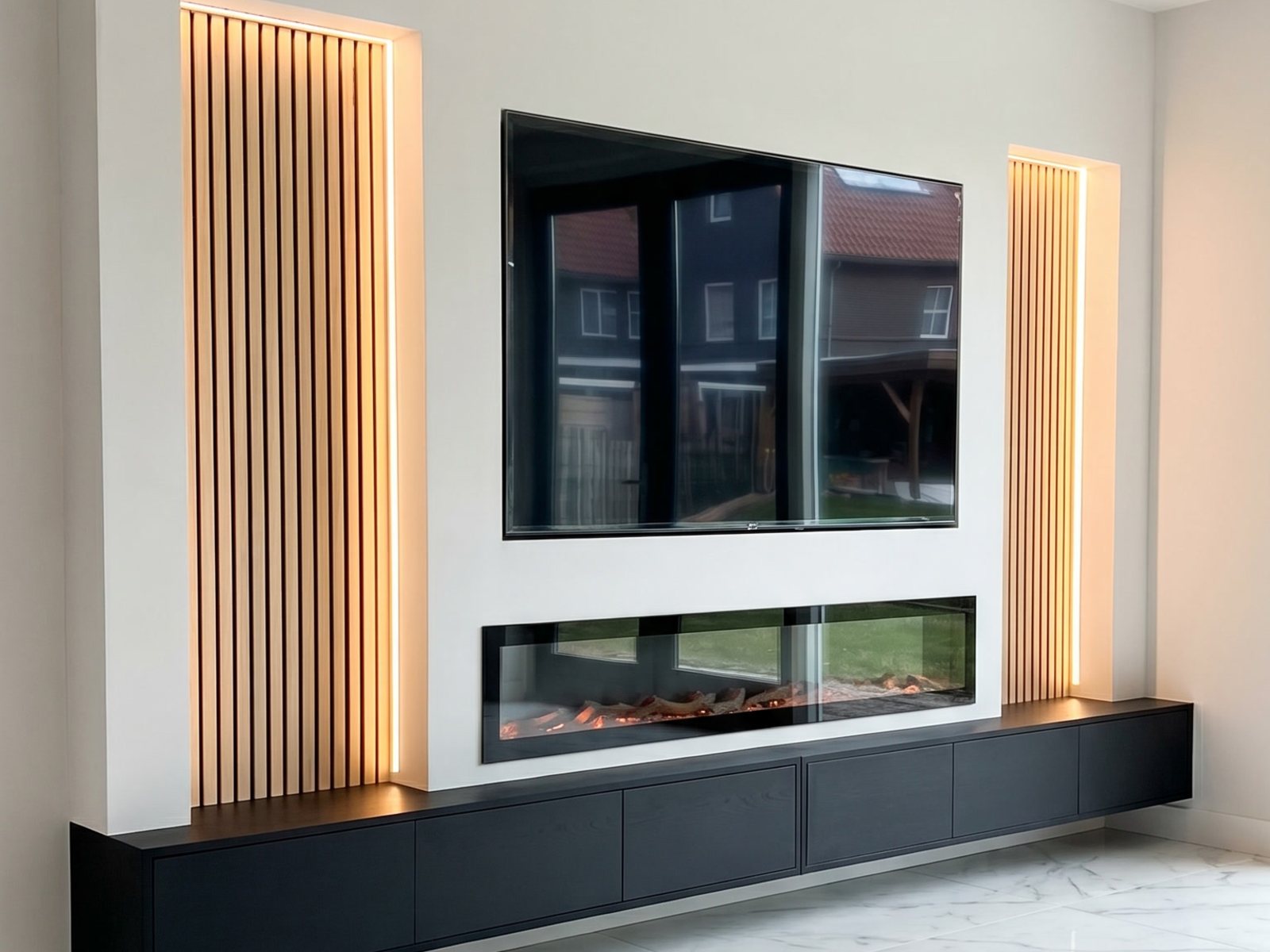 Tv wand idee: zwevende cinewall met verlichte houten panelen, verzonken tv, brede elektrische haard en zwart zwevend tv meubel