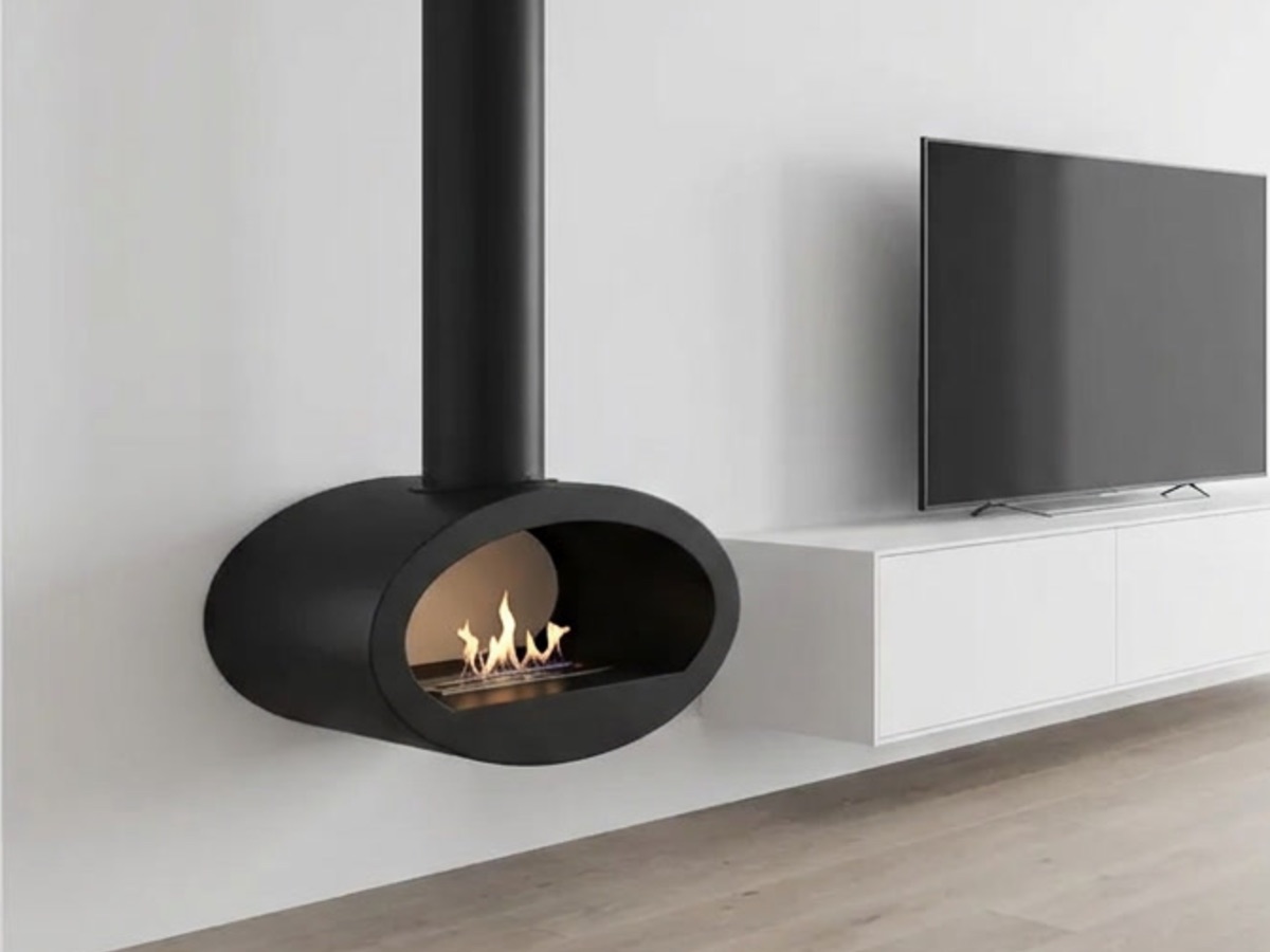Zwarte hangende bio ethanol haard met echte vlam aan een witte wand, naast een zwevend tv meubel